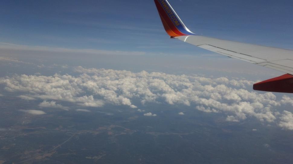 Free Image of Airplane Wing Flying Above Clouds 