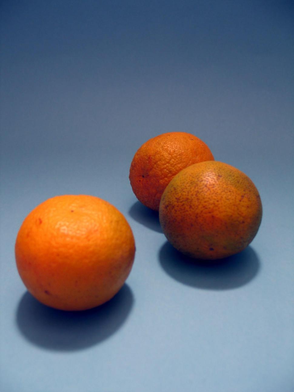Free Image of Three Oranges on Blue Surface 