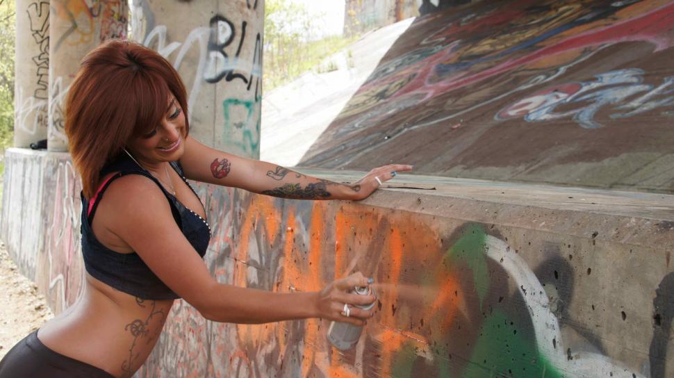 Free Image of Woman Spray Paints Graffiti 