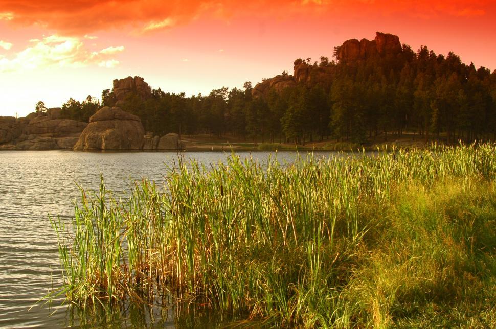 Free Image of Sunset over Calm Lake and Stone Hills 