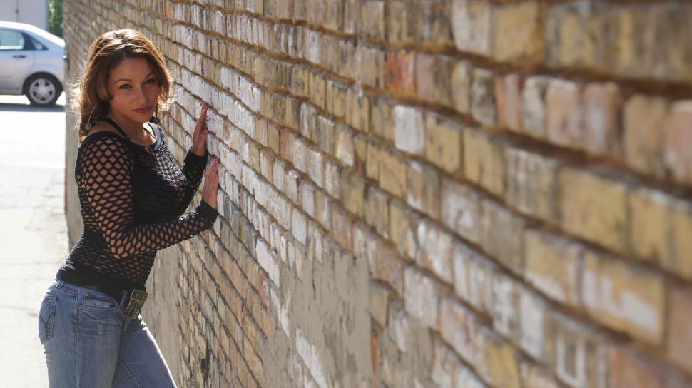 Free Image of Woman Against Brick Wall 