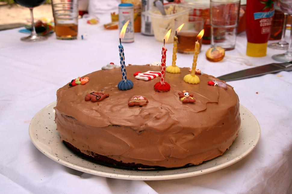 Free Image of Chocolate Birthday Cake With Lit Candles on Table 