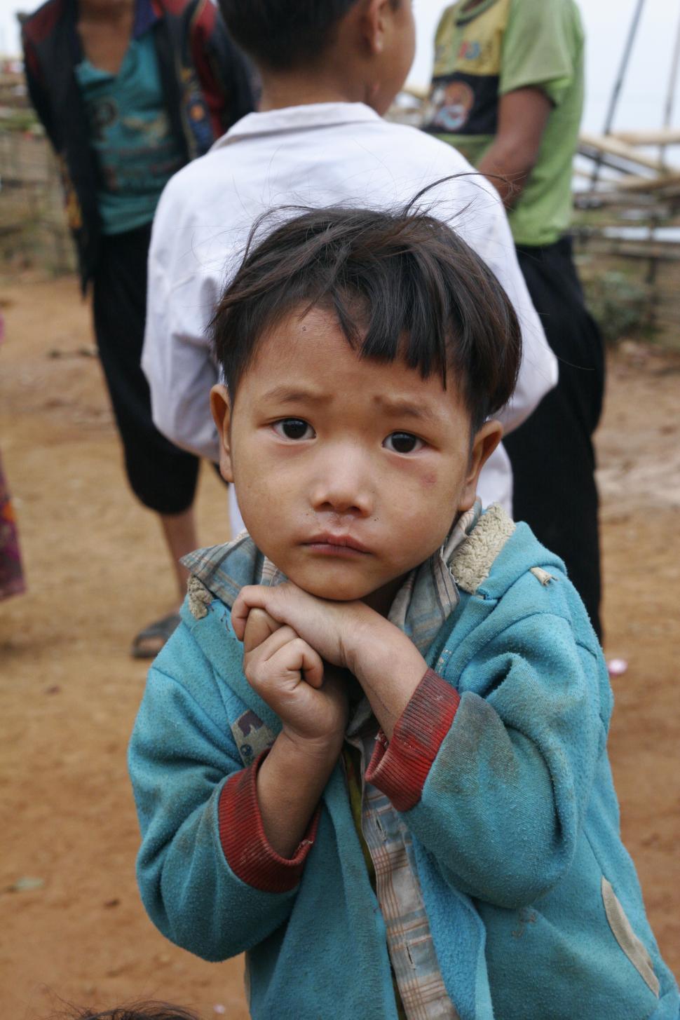 Free Image of Young Boy Standing In Front Of Group Of People 