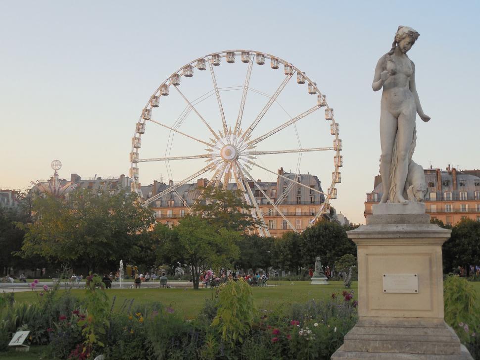 Free Image of Woman Statue Standing Next to Ferris Wheel 