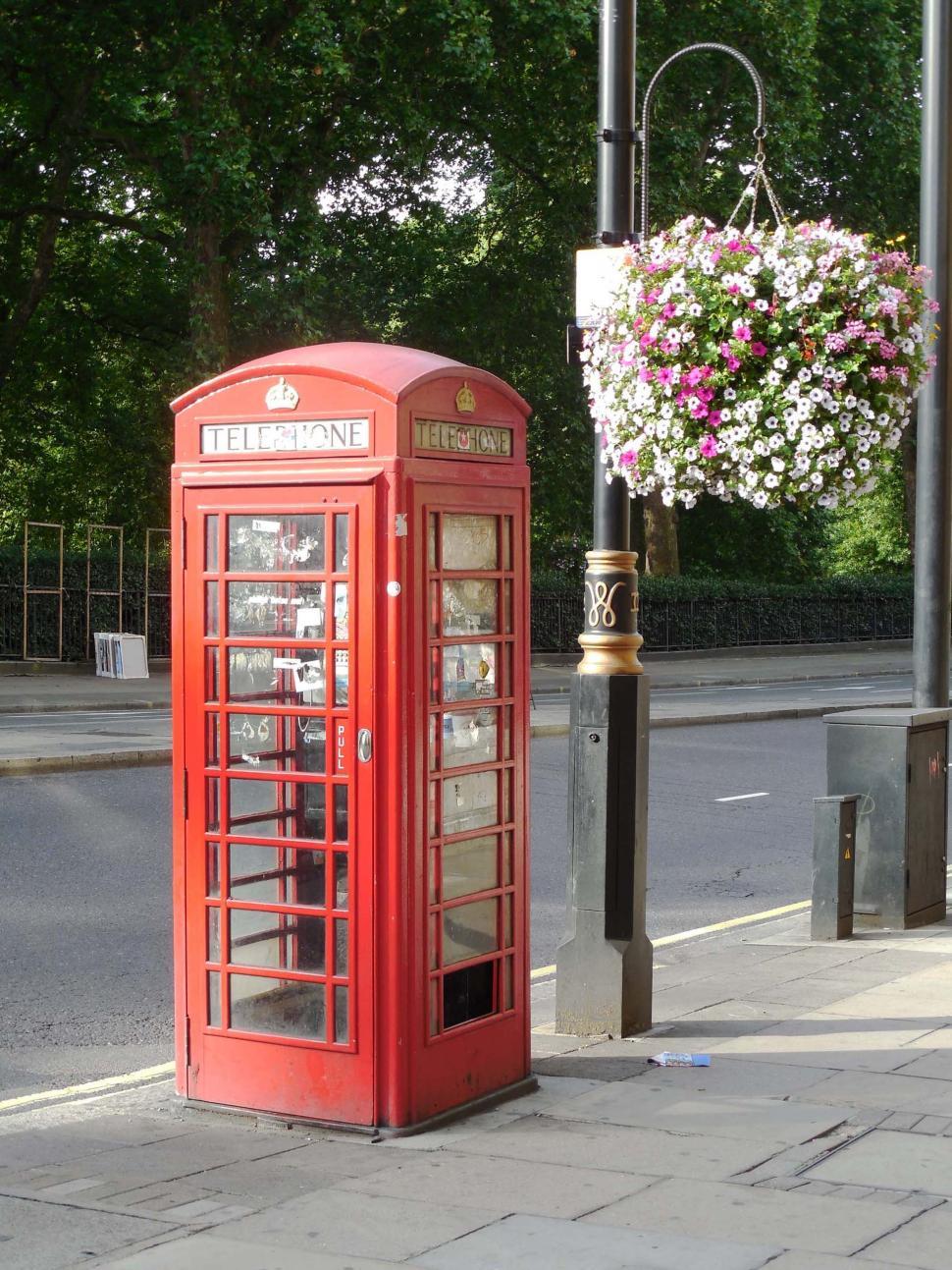 Free Image of Red Phone Booth by Side of Road 