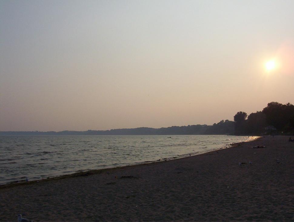 Free Image of Sun Setting Over Water at Beach 