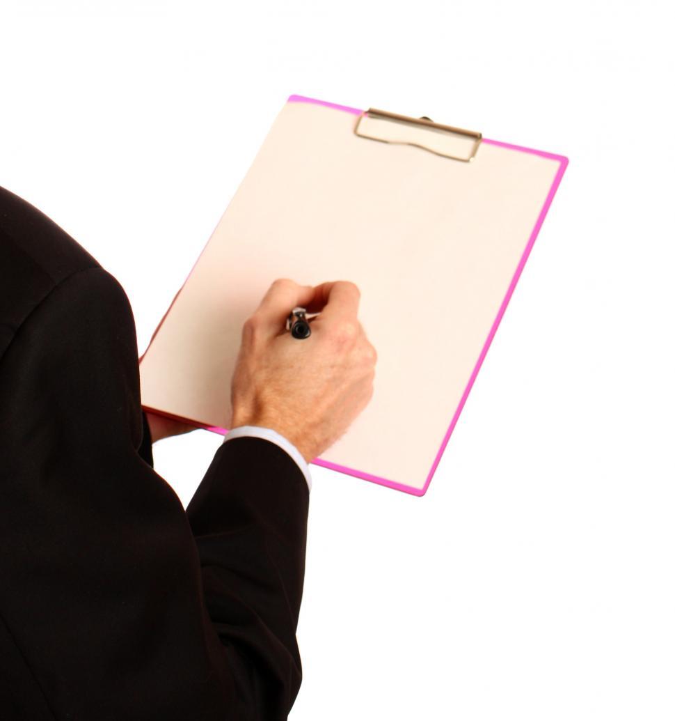 Free Image of A Young Businessman Holding A Clipboard And Pen 