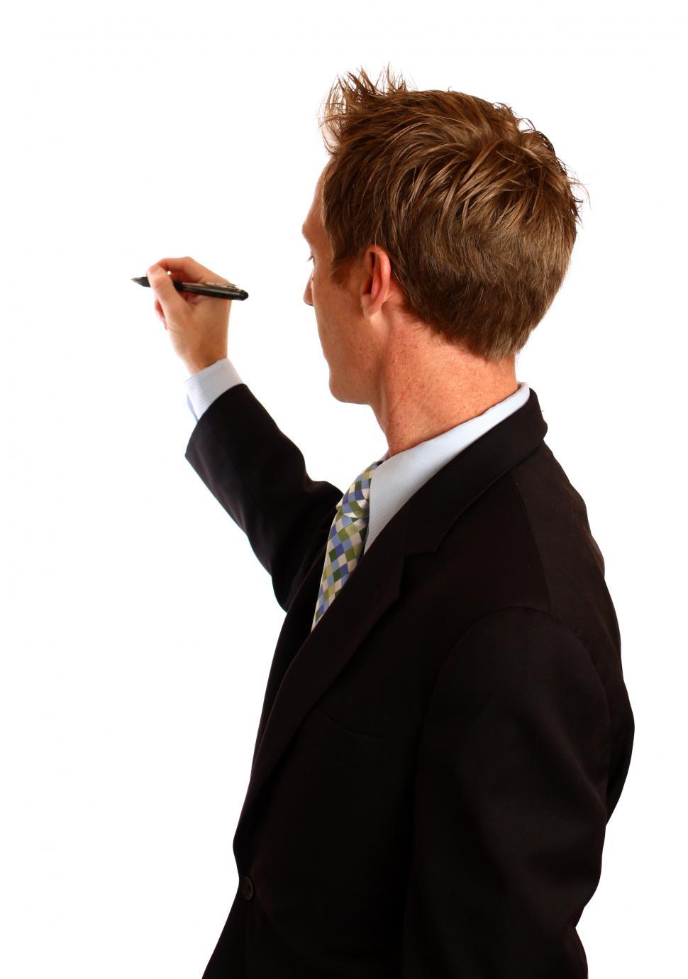 Free Image of A young businessman writing with a pen 