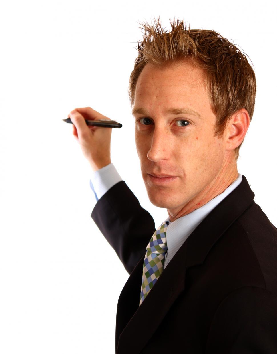 Free Image of A young businessman writing with a pen 