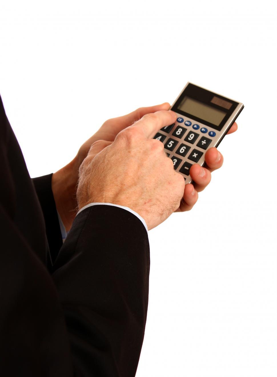 Free Image of A young businessman in a suit using a calculator 