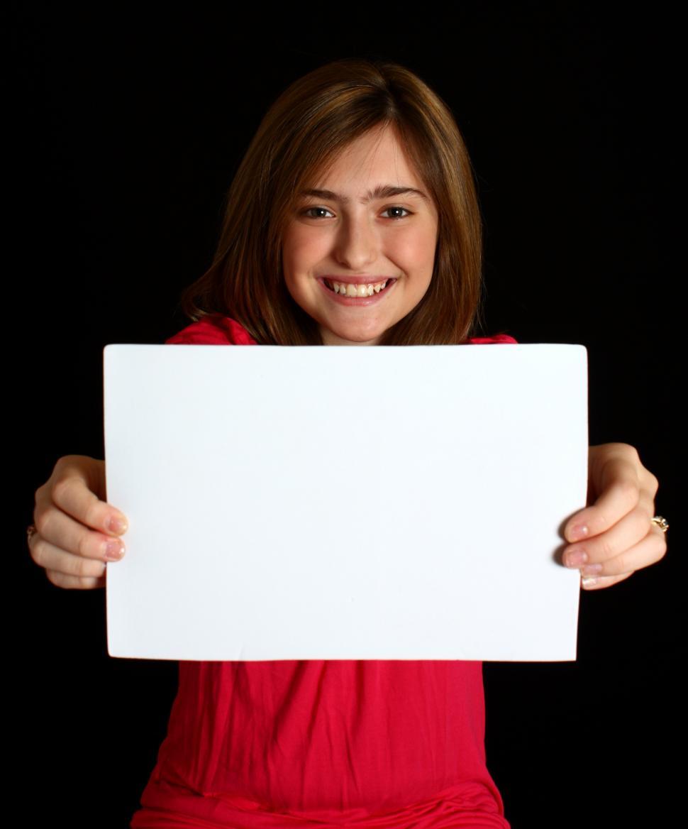 Free Image of A cute young girl holding a blank sign 