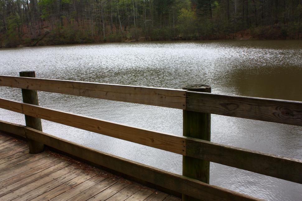 Free Image of A wooden fence by a lake 