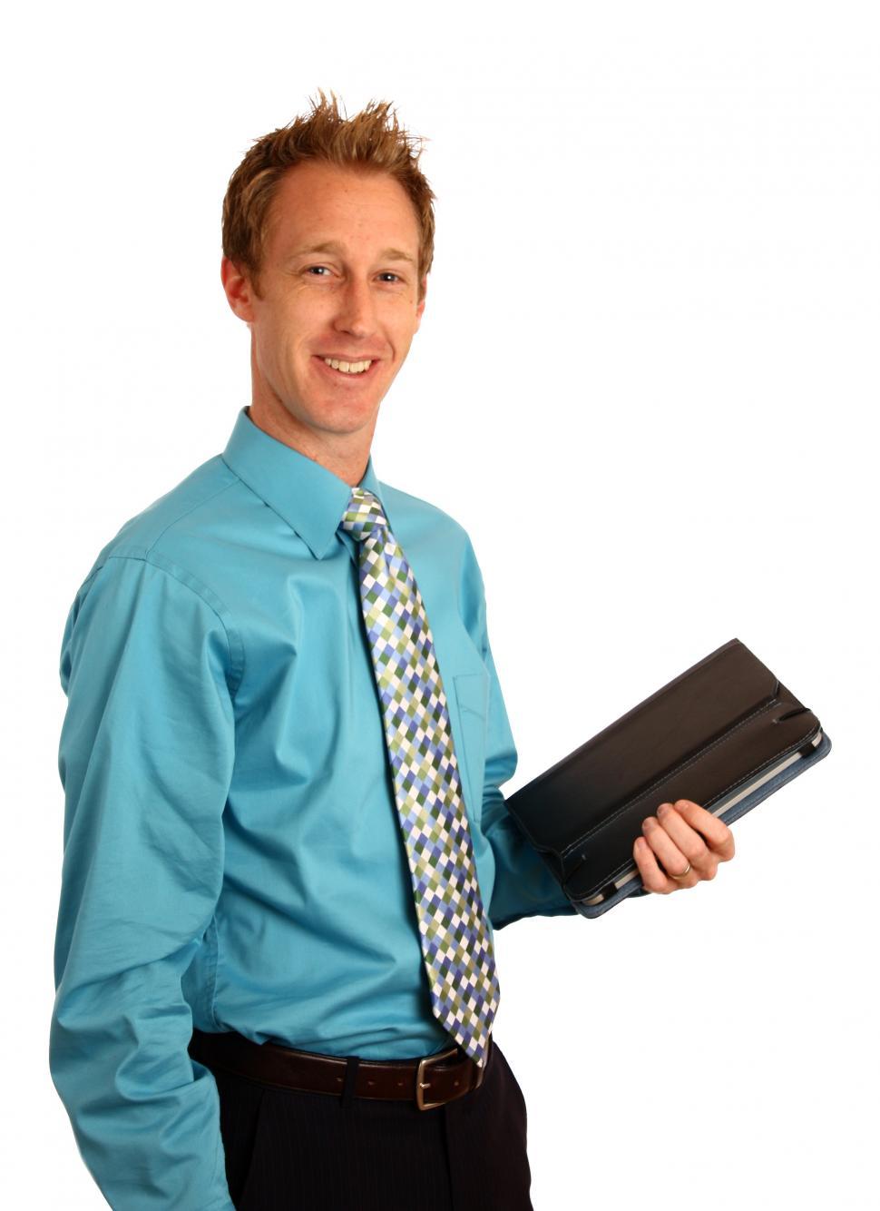 Free Image of A young businessman holding a binder 
