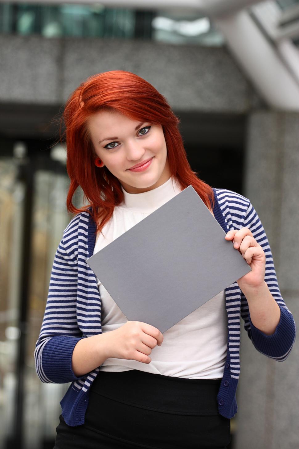 Free Image of A beautiful young woman holding a blank card 
