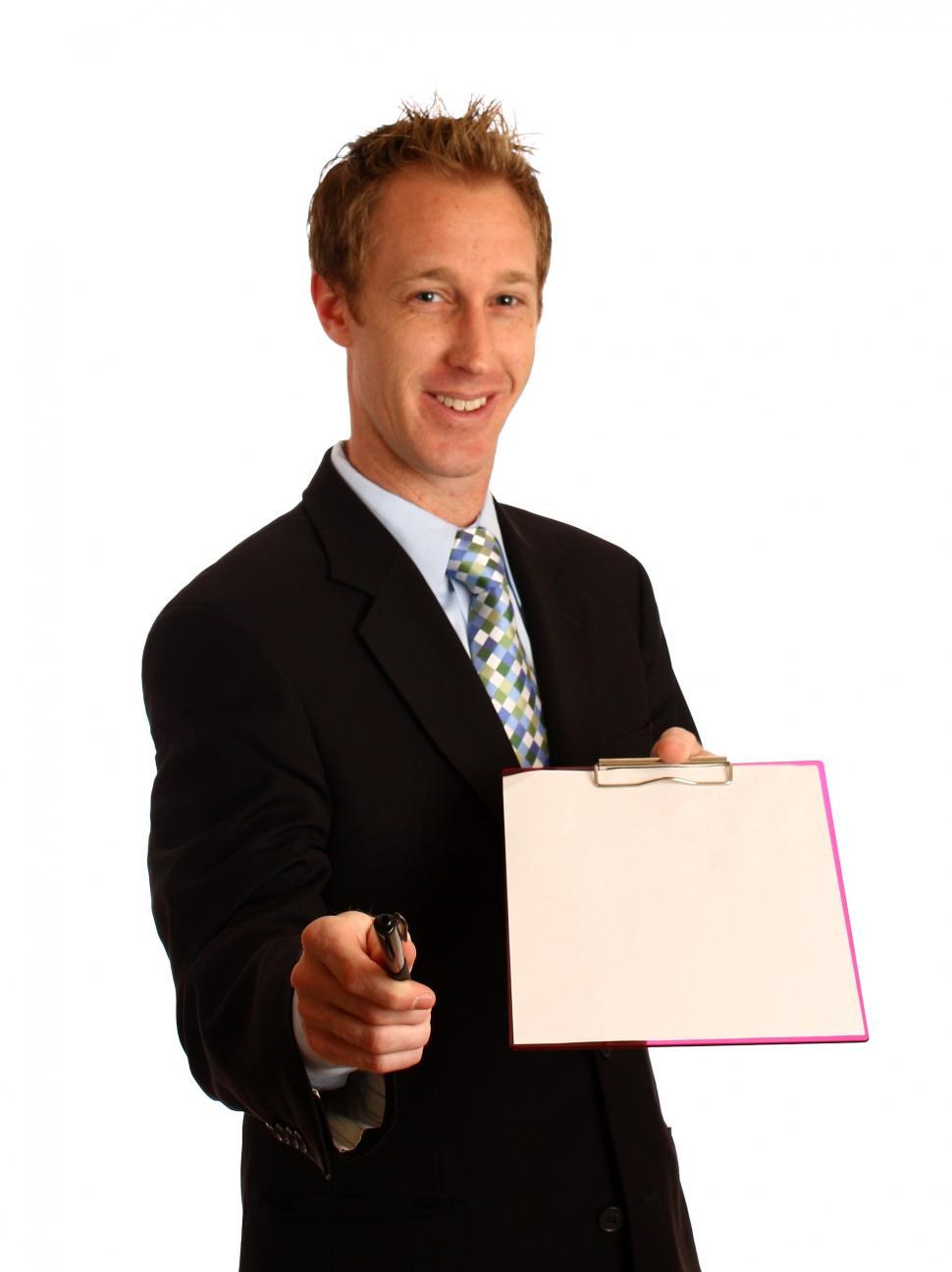 Free Image of A young businessman holding a clipboard and pen 