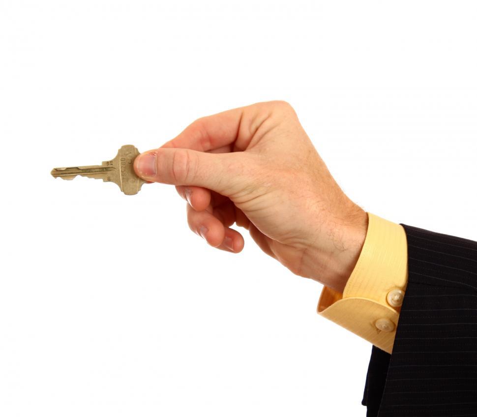 Free Image of A hand in a business suit holding a key 