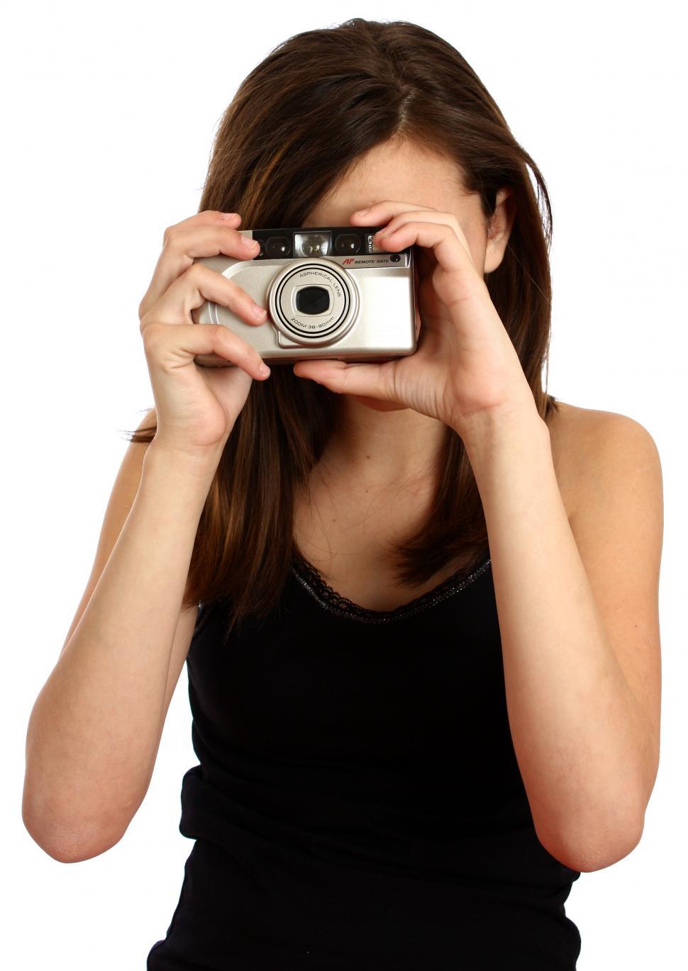 Free Image of A cute young girl taking a picture with a camera 