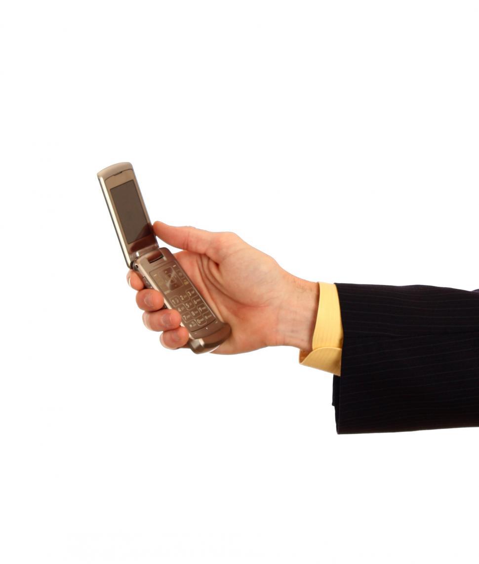 Free Image of A hand in a business suit holding a cell phone 