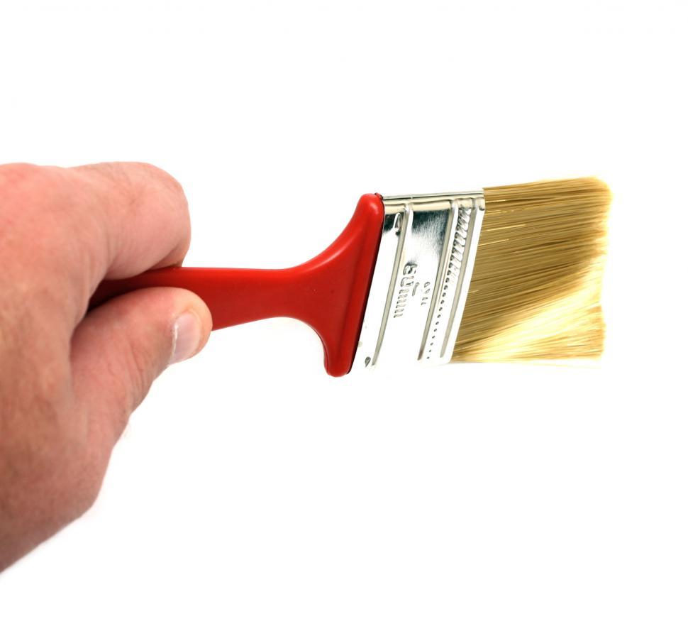 Free Image of A hand holding a paint brush isolated on a white background 