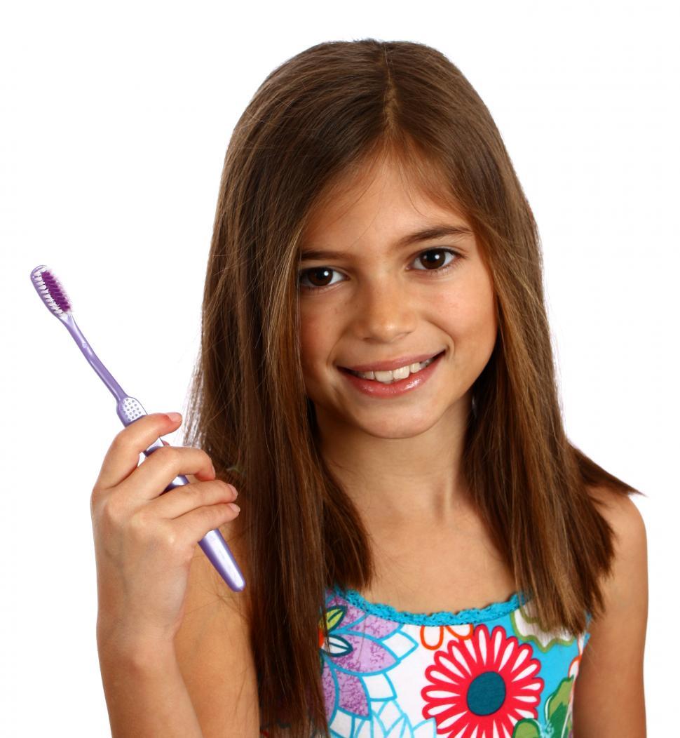 Free Image of A pretty young girl holding a toothbrush 