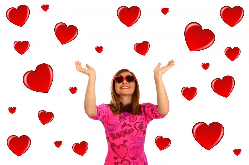 Free Image of A cute young girl dressed up for Valentines Day surrounded by hearts 