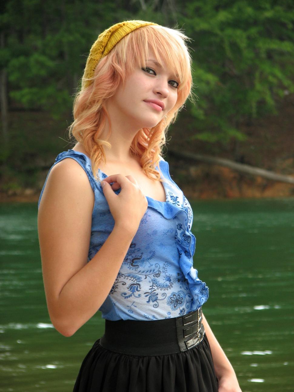 Free Image of A beautiful young woman posing by a lake 