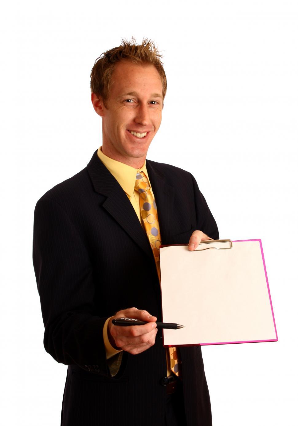 Free Image of A young businessman in a suit holding a clipboard and pen 