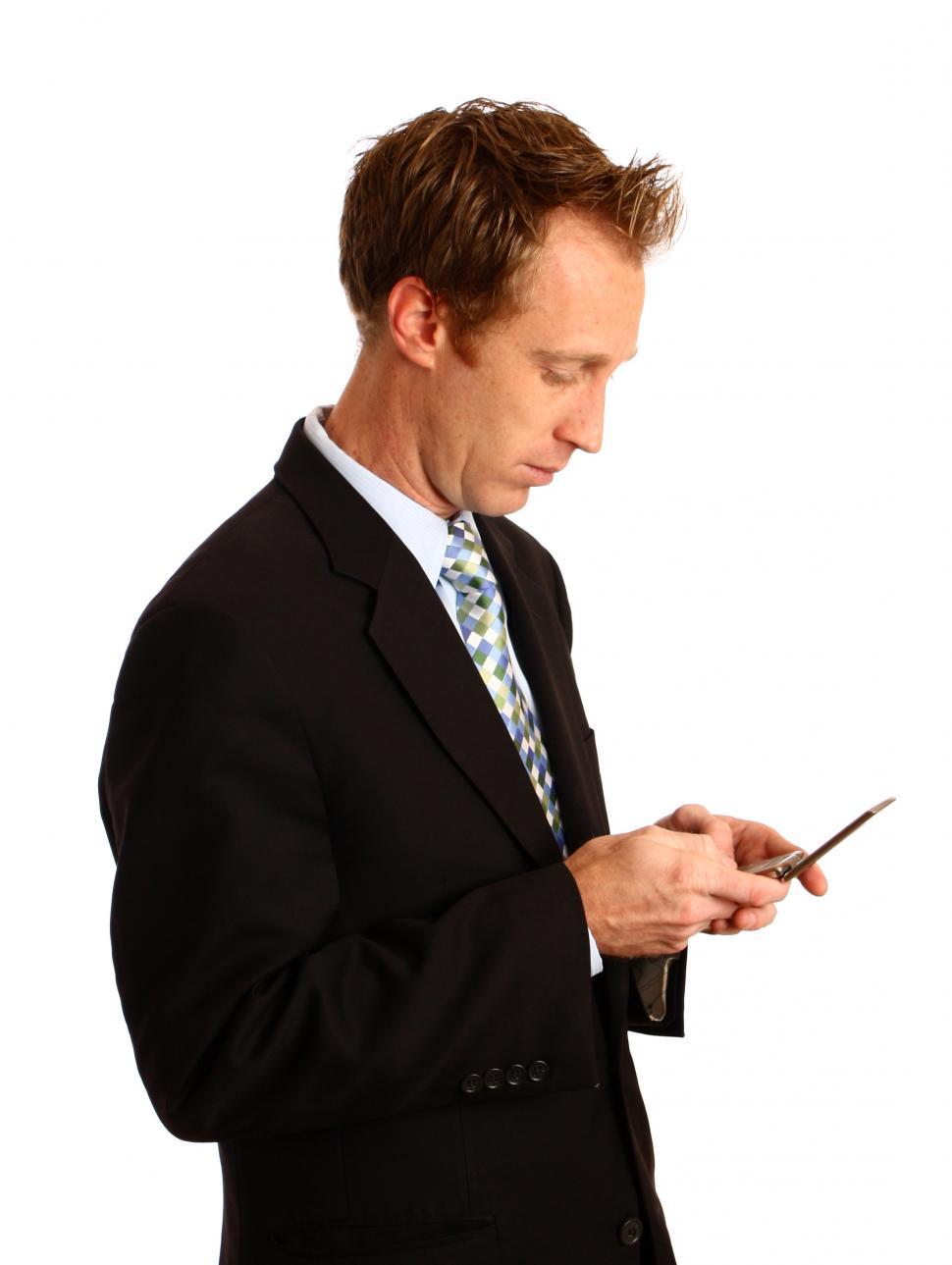Free Image of A young businessman texting on a cell phone 