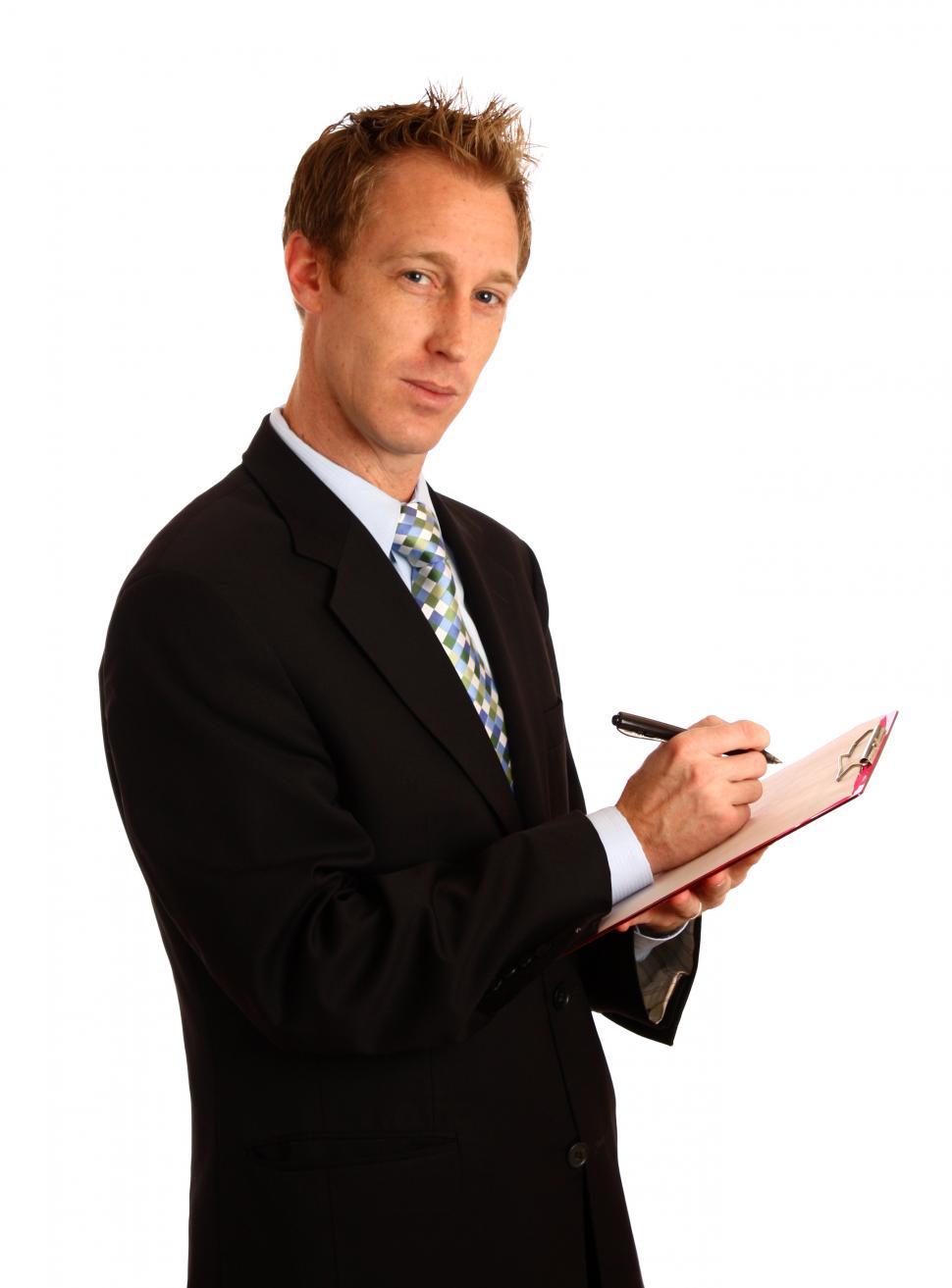 Free Image of A young businessman holding a clipboard and pen 