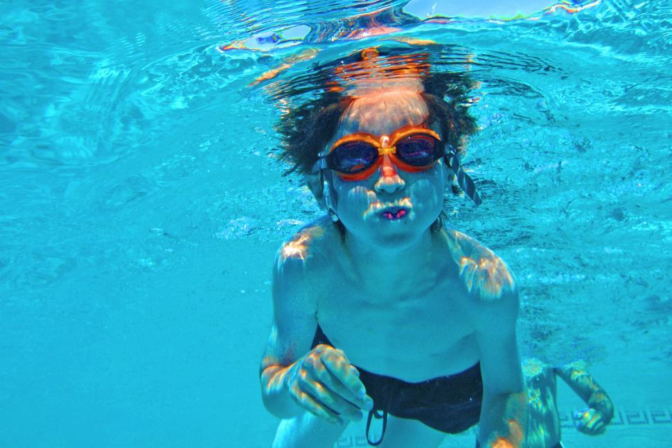 Free Image of Child swimming underwater in a swimming pool 