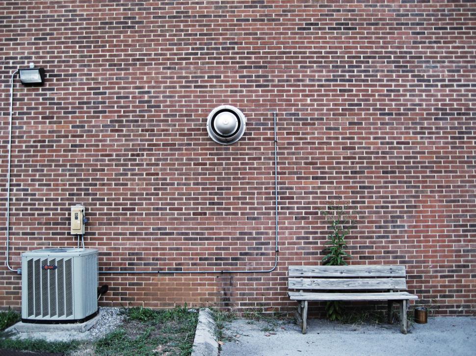 Free Image of Brick Wall With Heater and Bench 