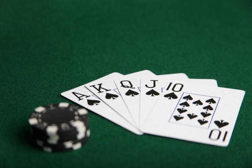 Free Image of Royal flush of spades with black poker chips. 