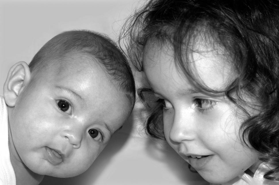 Free Image of Two young sisters facing each other - a toddler and a baby 
