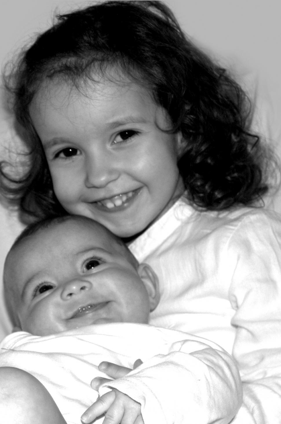 Free Image of Two happy smiling sisters - a toddler holding a little cute baby 