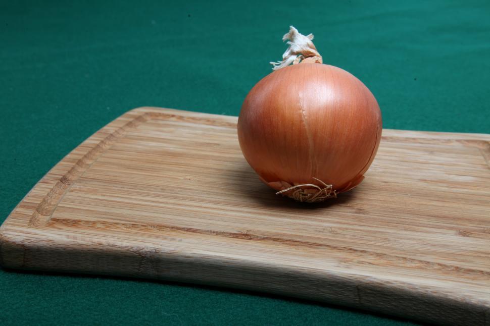 Free Image of Onion on wooden cutting board. 
