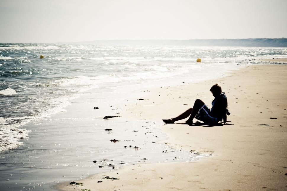 Free Image of Girl sitting on the beach 
