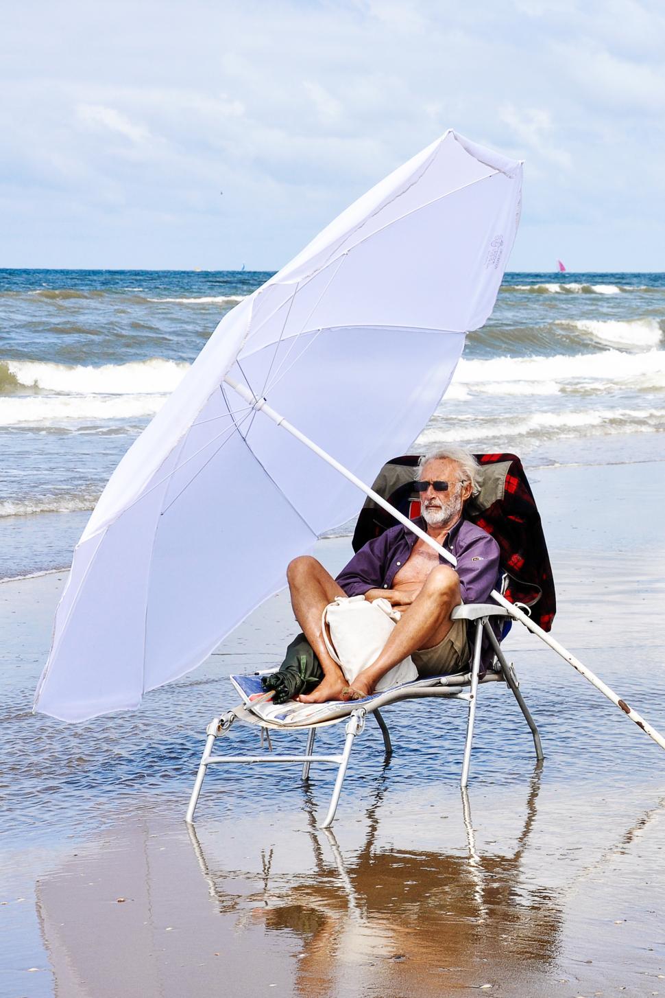 Free Image of Man relaxing on beach 