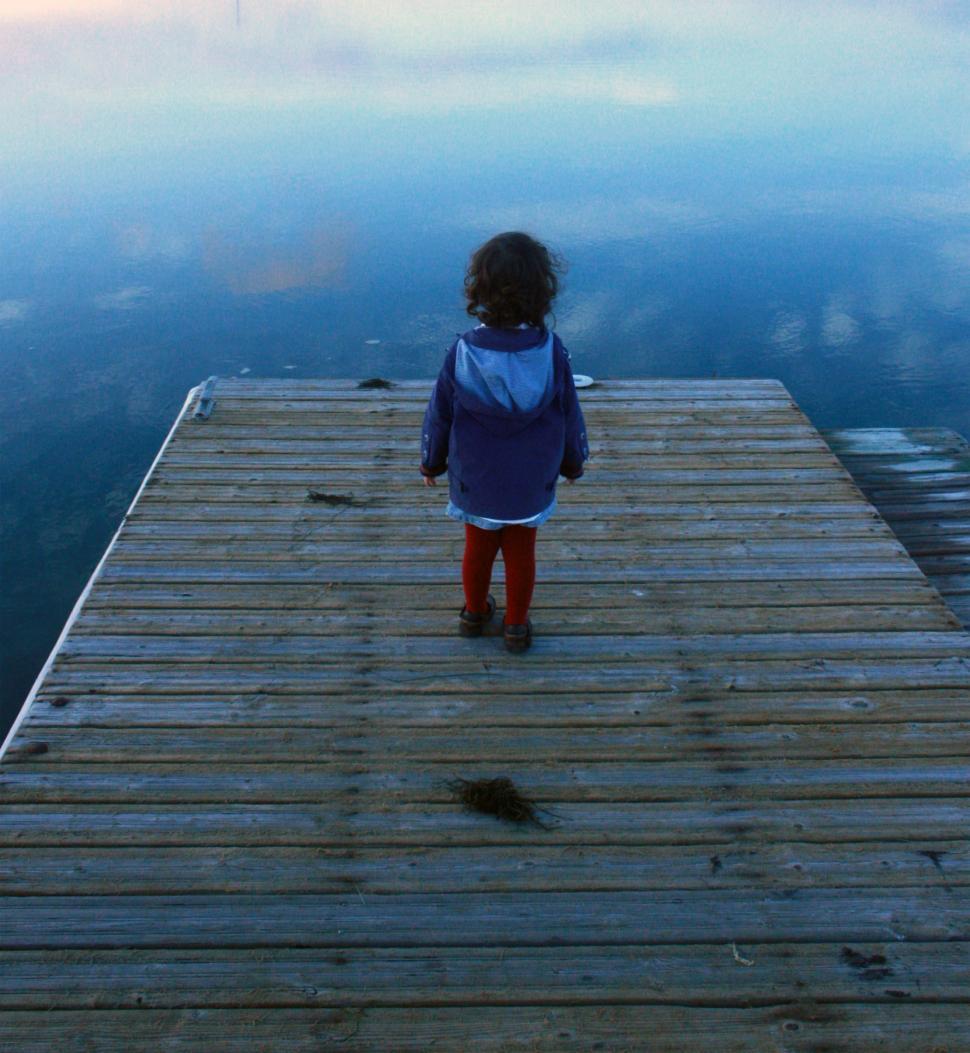 Free Image of Child looking out on the pier 