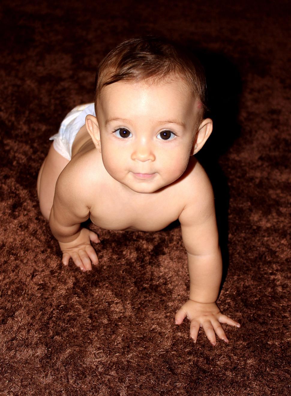 Free Image of Sweet baby crawling on carpet 
