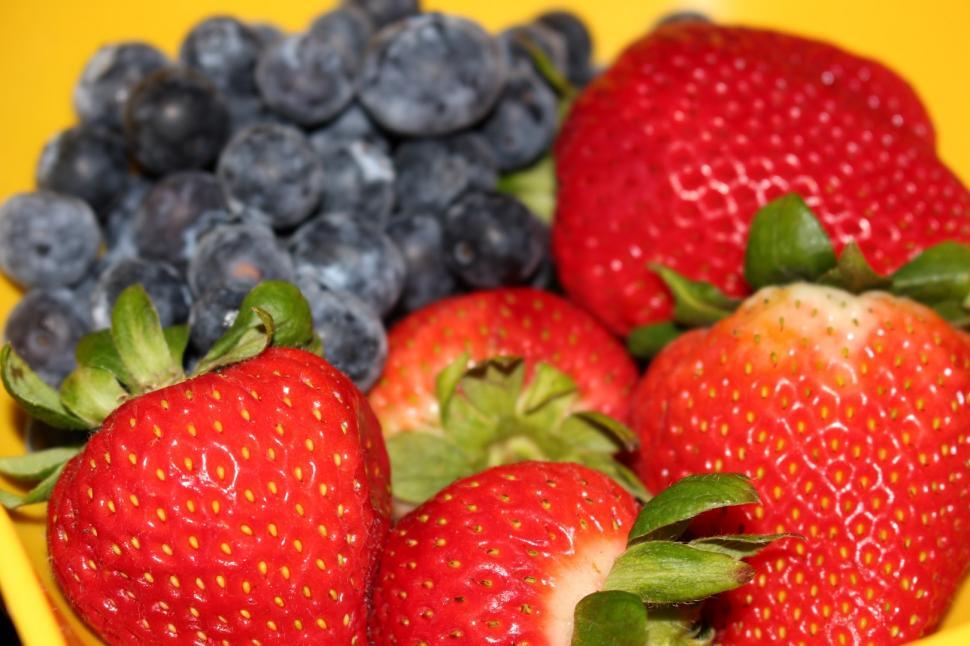 Free Image of Strawberries and Blueberries in a yellow Colander.  