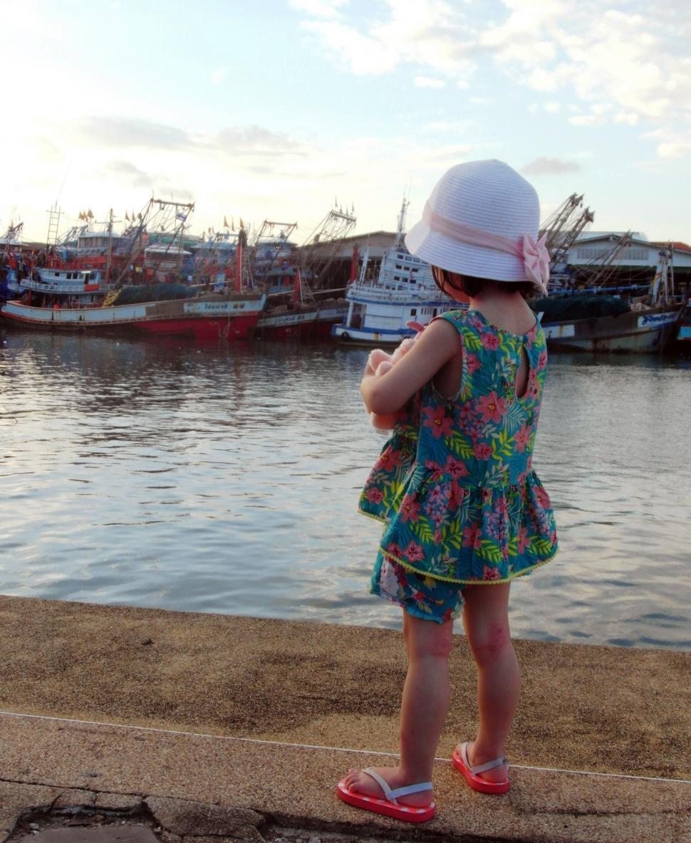 Free Image of Girl Looking at Fishing Boats 