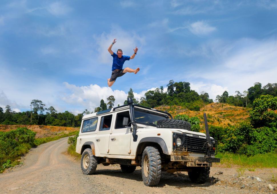 Free Image of A person jumps over a car 