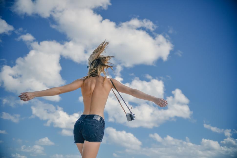 Free Image of Woman with open arms carrying camera 