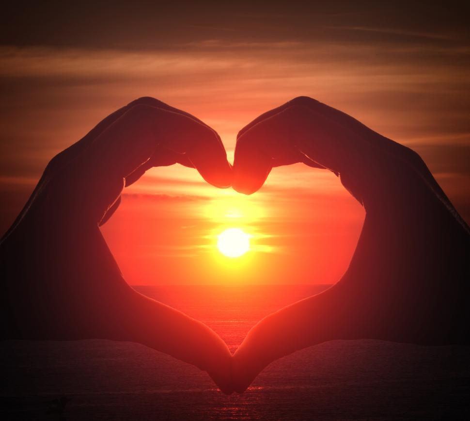 Download Free Stock Photo of Hand silhouette in heart shape with sunset in the middle and oce 