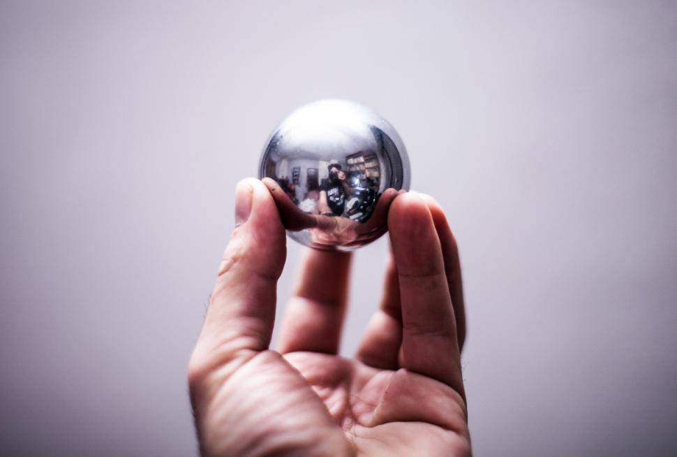Free Image of Hand Holding Silver Ball in Air 