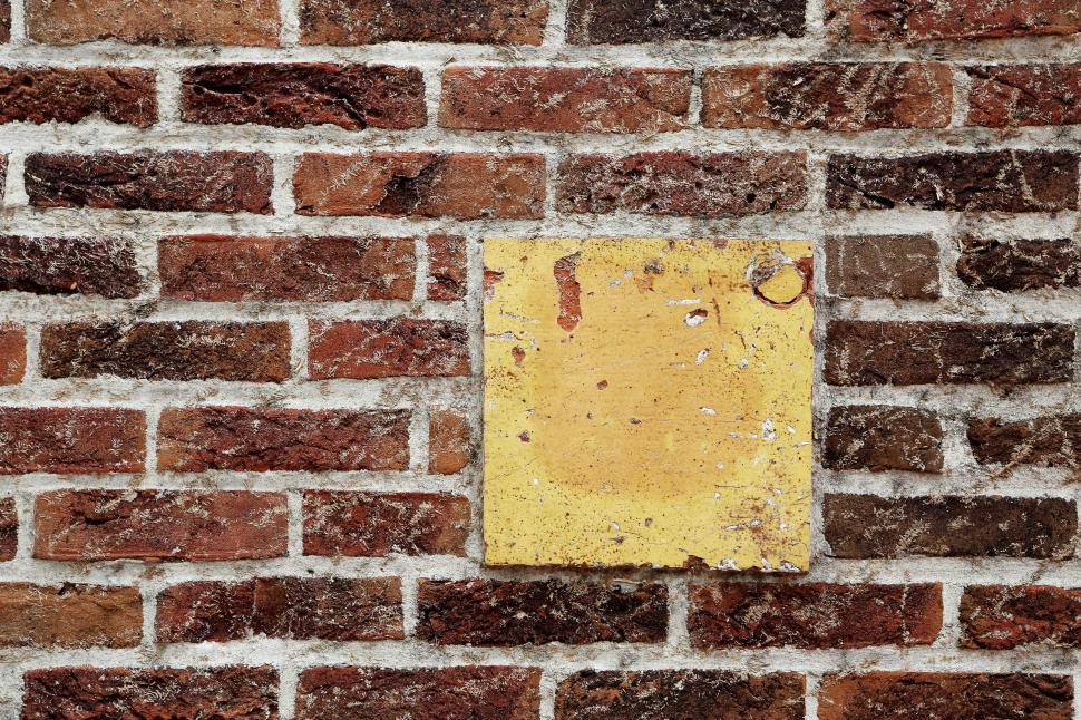 Free Image of Brick Wall With Yellow Sign 
