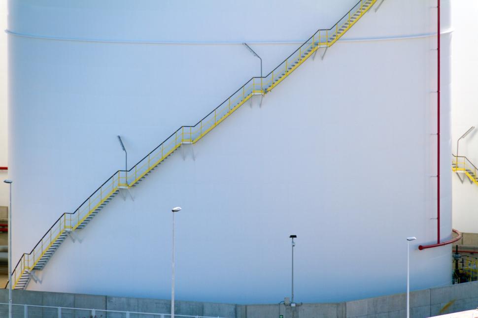 Free Image of Yellow stairs on a white storage tank 