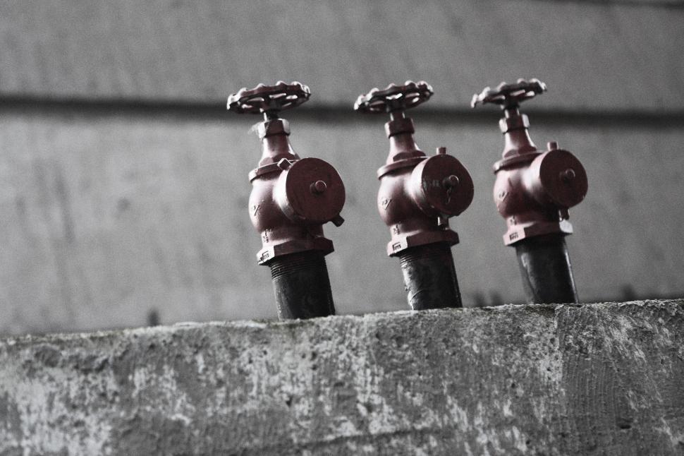 Free Image of Row of Water Faucets on Cement Wall 