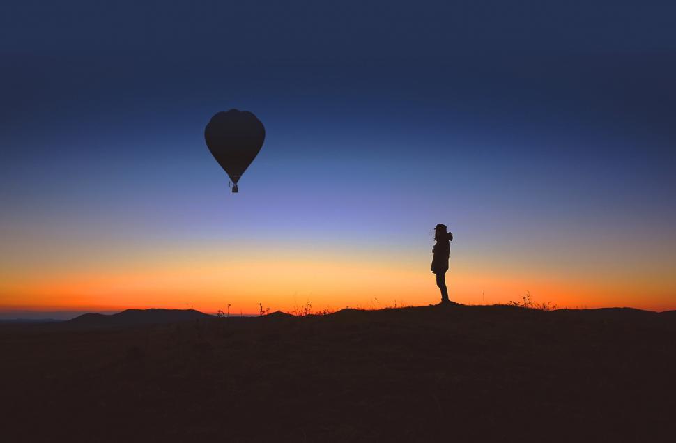 Download Free Stock Photo of A lone person observes an hot air balloon at sunrise 