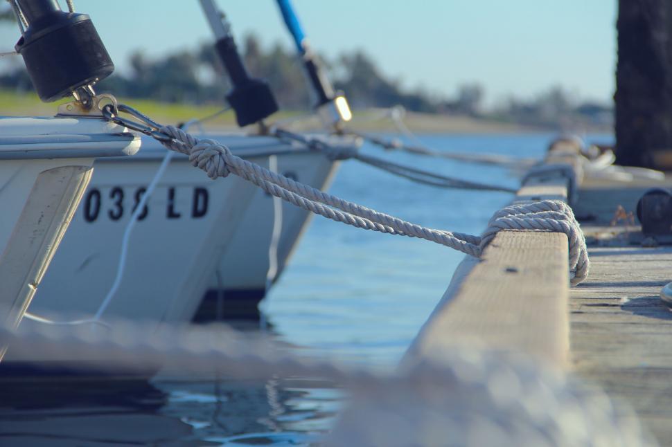 Free Image of Boat Tied Up to Dock Next to Water 
